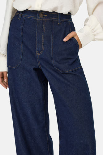 Jean délavé bleu marine de JDY, avec des poches brodées et des boutons dorés.