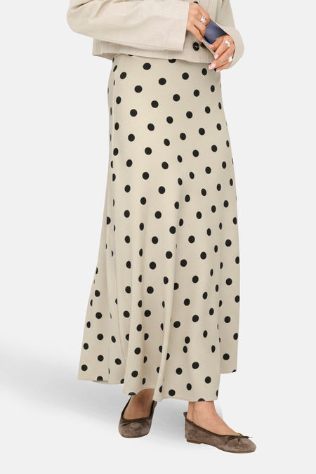 Lange ecru rok van JDY, met een zwart stippenpatroon en zichtbare bruine ballerina's.
