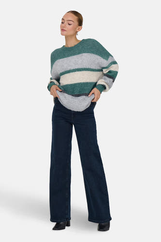Groene trui met ronde hals van JDY, met horizontale strepen in grijs en wit, gecombineerd met donkere jeans.
