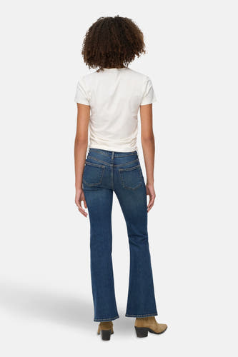 Jean flare bleu marine de JDY, vu de l'arrière, associé à un T-shirt blanc et des bottes en cuir de mouton.