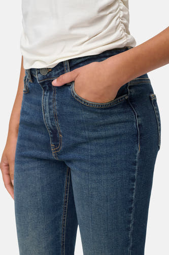 Jean flare bleu marine de JDY, avec des poches et une main dans la poche.