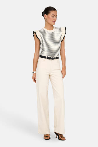 Pull blanc de JDY, avec des rayures noires et des manches froncées, porté avec une ceinture noire et un pantalon off-white.