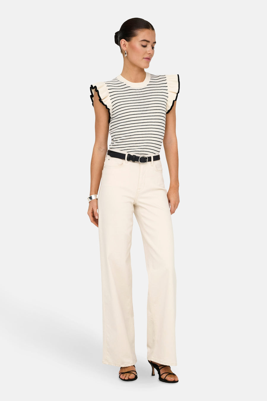 Pull blanc de JDY, avec des rayures noires et des manches froncées, porté avec une ceinture noire et un pantalon off-white.