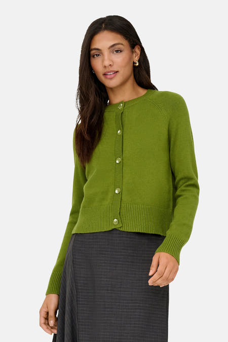 Cardigan vert de ONLY, avec des manches longues et une fermeture à boutons, porté avec une jupe grise.