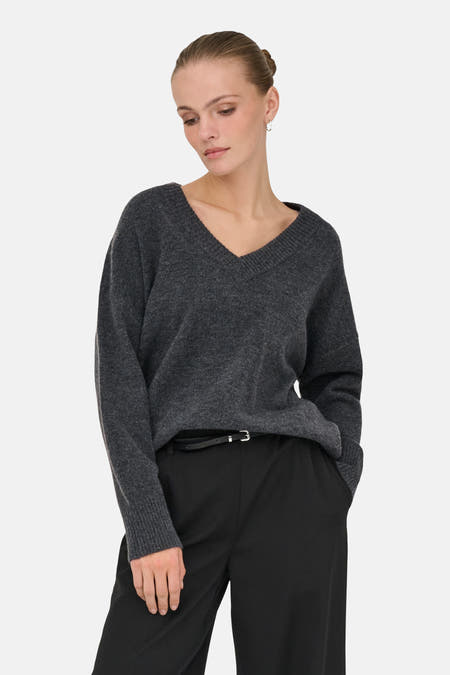 Sweat gris à col V d'ONLY®, associé à un pantalon noir et une ceinture.