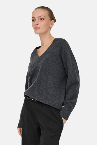 Sweat gris à col V d'ONLY, porté avec un pantalon noir et une ceinture.