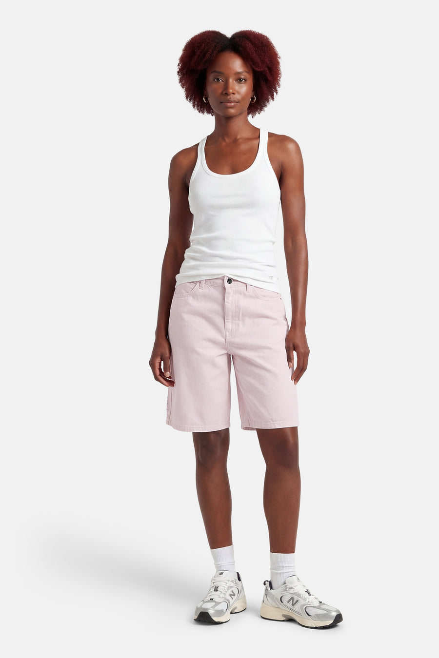 Short rose de ONLY, porté avec un débardeur blanc et des chaussettes blanches avec des baskets argentées.