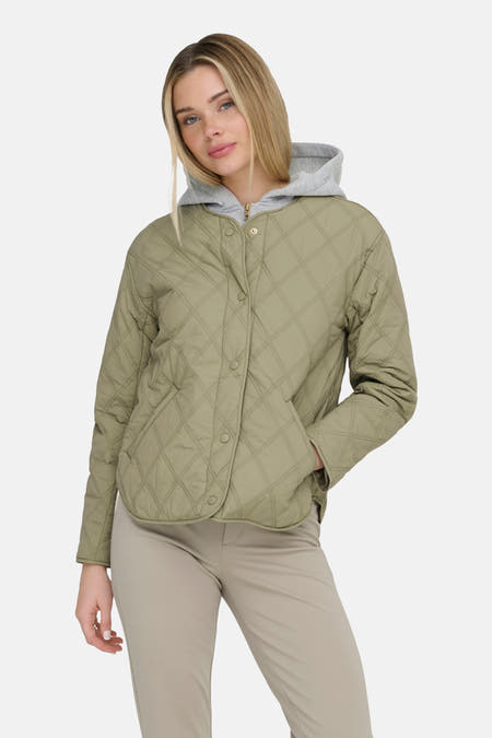 Veste courte verte de ONLY, avec un motif matelassé en losange et fermeture à boutons, combinée avec un sweat à capuche gris et un pantalon beige.