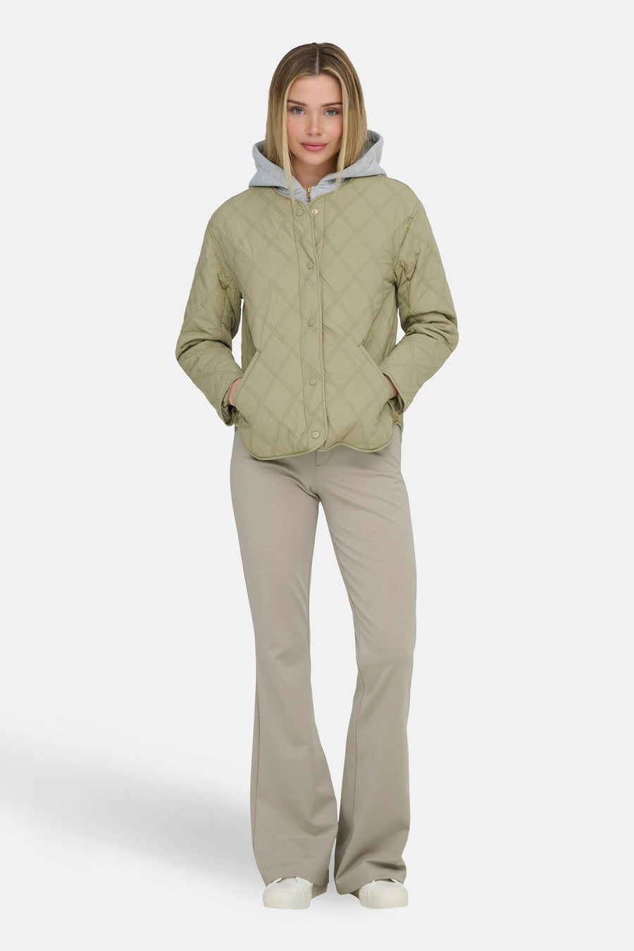 Groene korte jas van ONLY, met een geruit stiksel en gedragen met beige broek.
