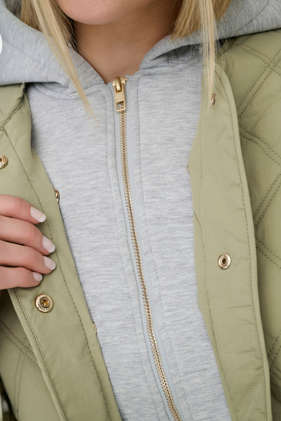 Groene korte jas van ONLY, met gouden knopen en ruitpatroon, gecombineerd met een grijze hoodie.