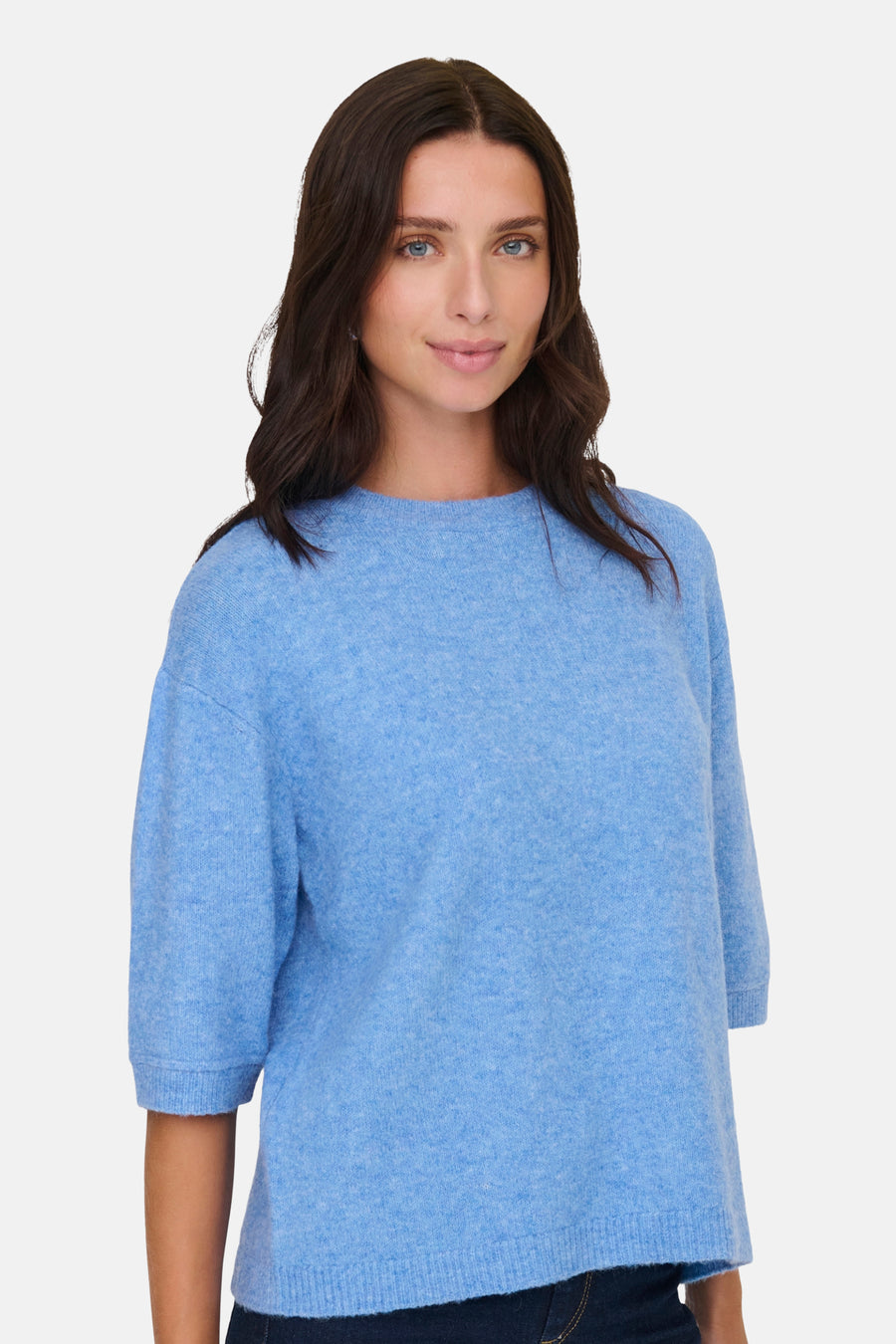 Vrouw in blauwe gebreide trui, lichte achtergrond.