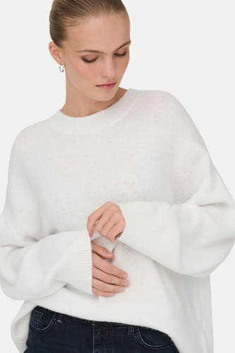 T-shirt blanc à col rond de JDY, avec des manches longues et une coupe décontractée, porté avec des jeans foncés.