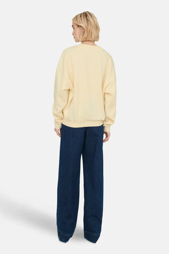Gilet écru de ONLY, avec des manches longues, associé à un jean bleu marine large.