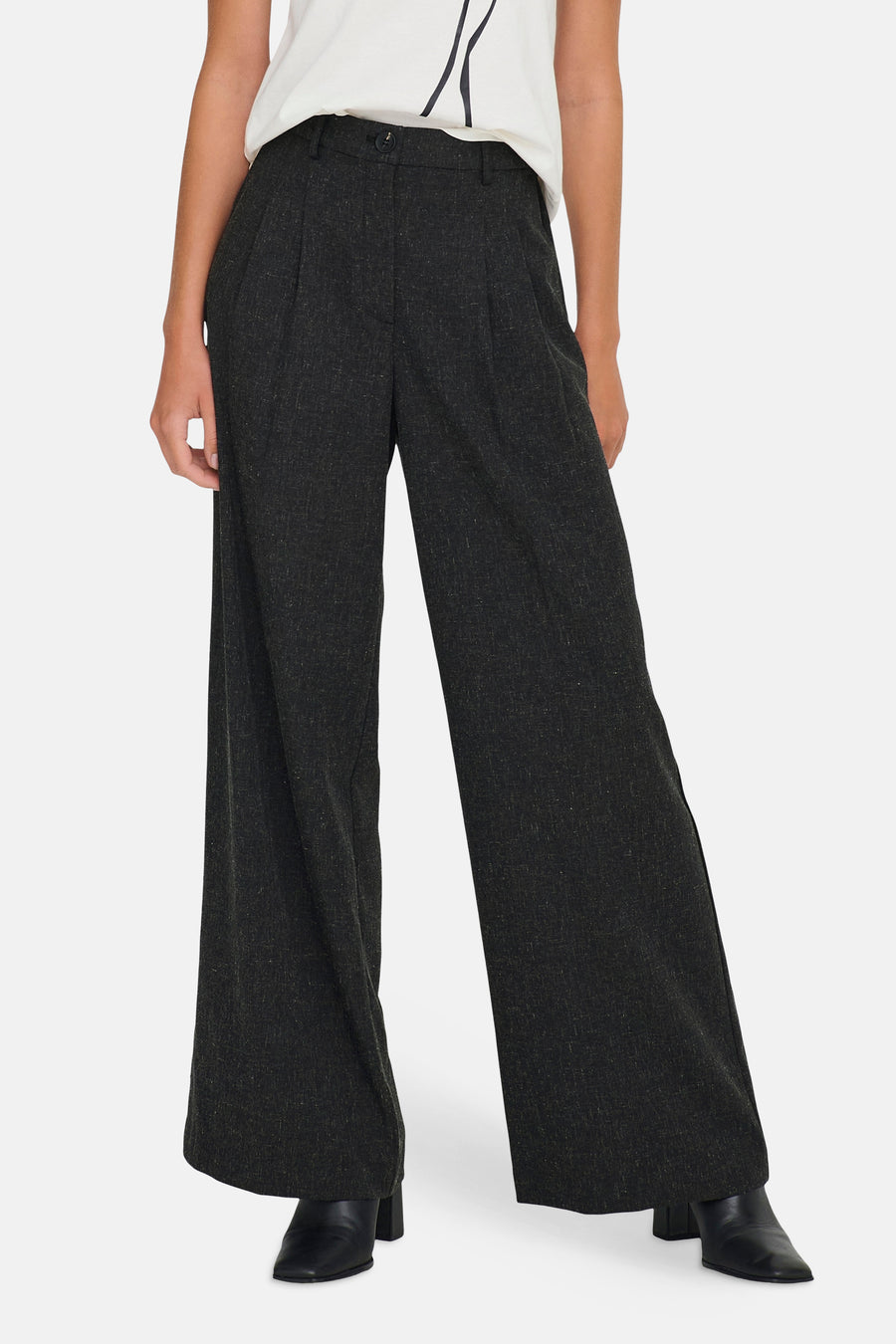 Grijze wijde pantalon met plooien en zwarte laarsjes.
