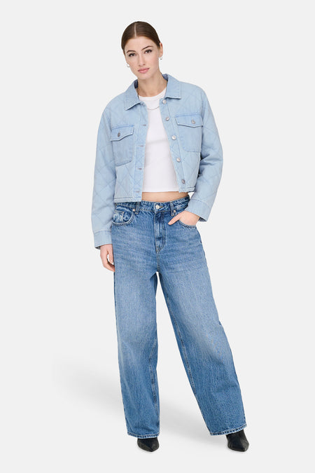 Jeansjas van lichtblauw denim van ONLY, met diamantvormig stiksel en gedragen met wijde jeans en zwarte laarsjes.

