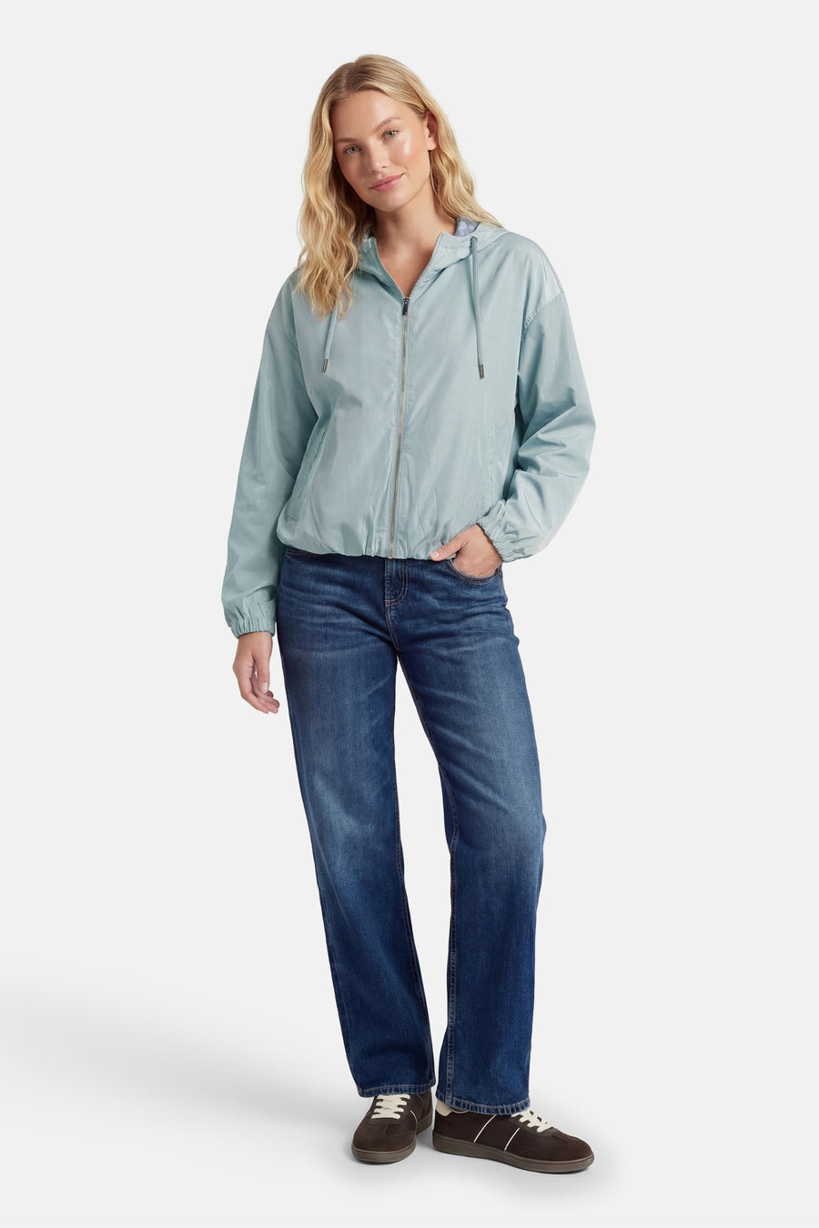 Veste verte de ONLY, avec fermeture éclair, capuche et portée avec des jeans bleus et des chaussures marrons.