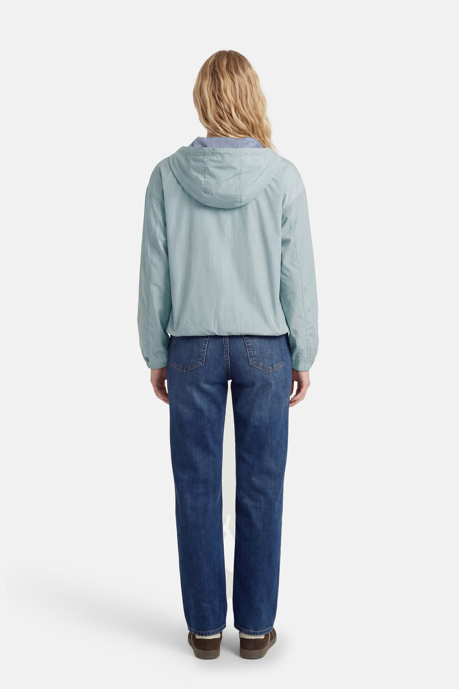 Veste courte verte de ONLY, avec un capuchon, associée à des pantalons en cuir sombres et des chaussures brunes, vue de derrière.