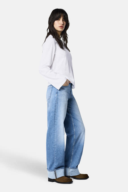 Wijde jeans van lichtblauw denim van ONLY, met omgeslagen pijpen en gedragen met een wit shirt.