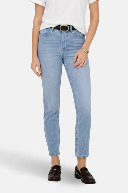Jean mom en denim bleu clair de ONLY, porté avec un t-shirt blanc, une ceinture noire et des loafers marrons.
