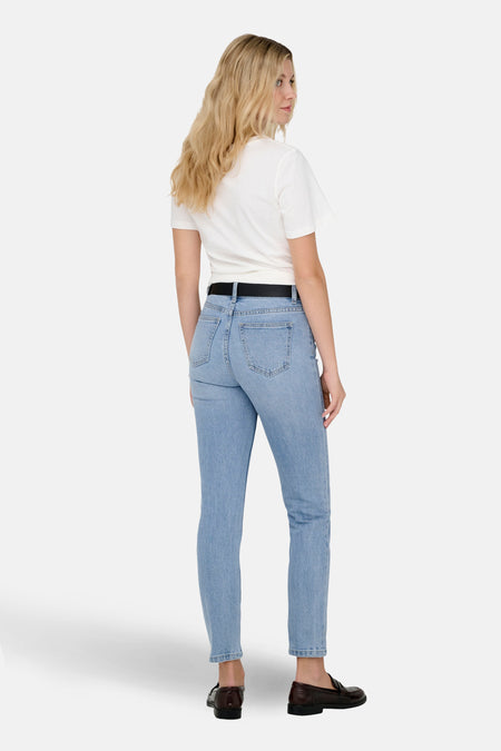 Jean mom bleu clair d'ONLY, avec une ceinture noire et des loafers marrons.