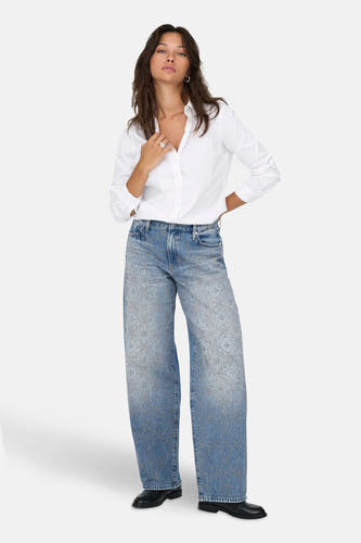 Lichtblauwe rechte jeans van ONLY, met bloemmotieven en gedragen met een wit overhemd en zwarte schoenen.
