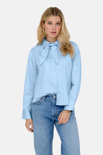 Chemise bleue à manches longues de JDY, avec détail de nœud et portée avec un jean.