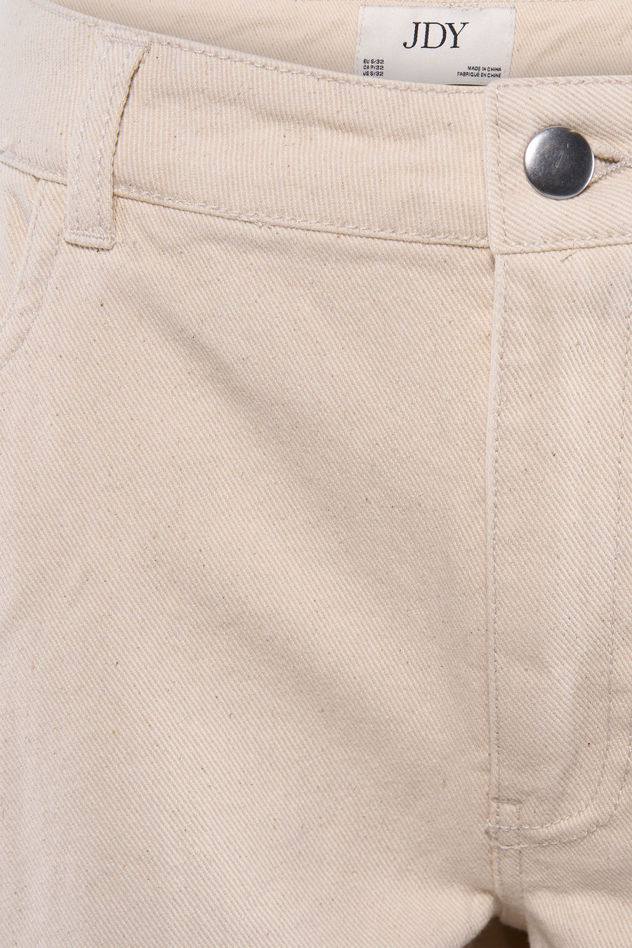 Jean de couleur beige de JDY, avec un tissu uni et une fermeture à boutons argentés.