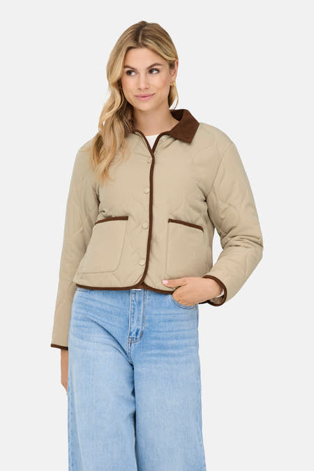 Beige korte jas van JDY, met bruine details en gedragen met een blauwe jeans.