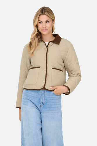 Beige korte jas van JDY, met bruine details en gedragen met een blauwe jeans.