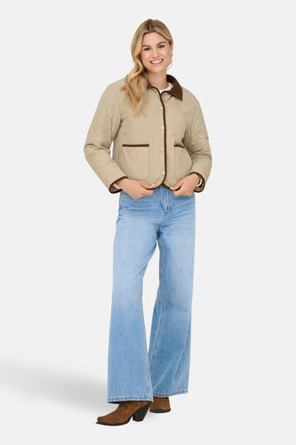 Beige korte jas van JDY, met bruine details en gedragen met wijde jeans en laarzen.
