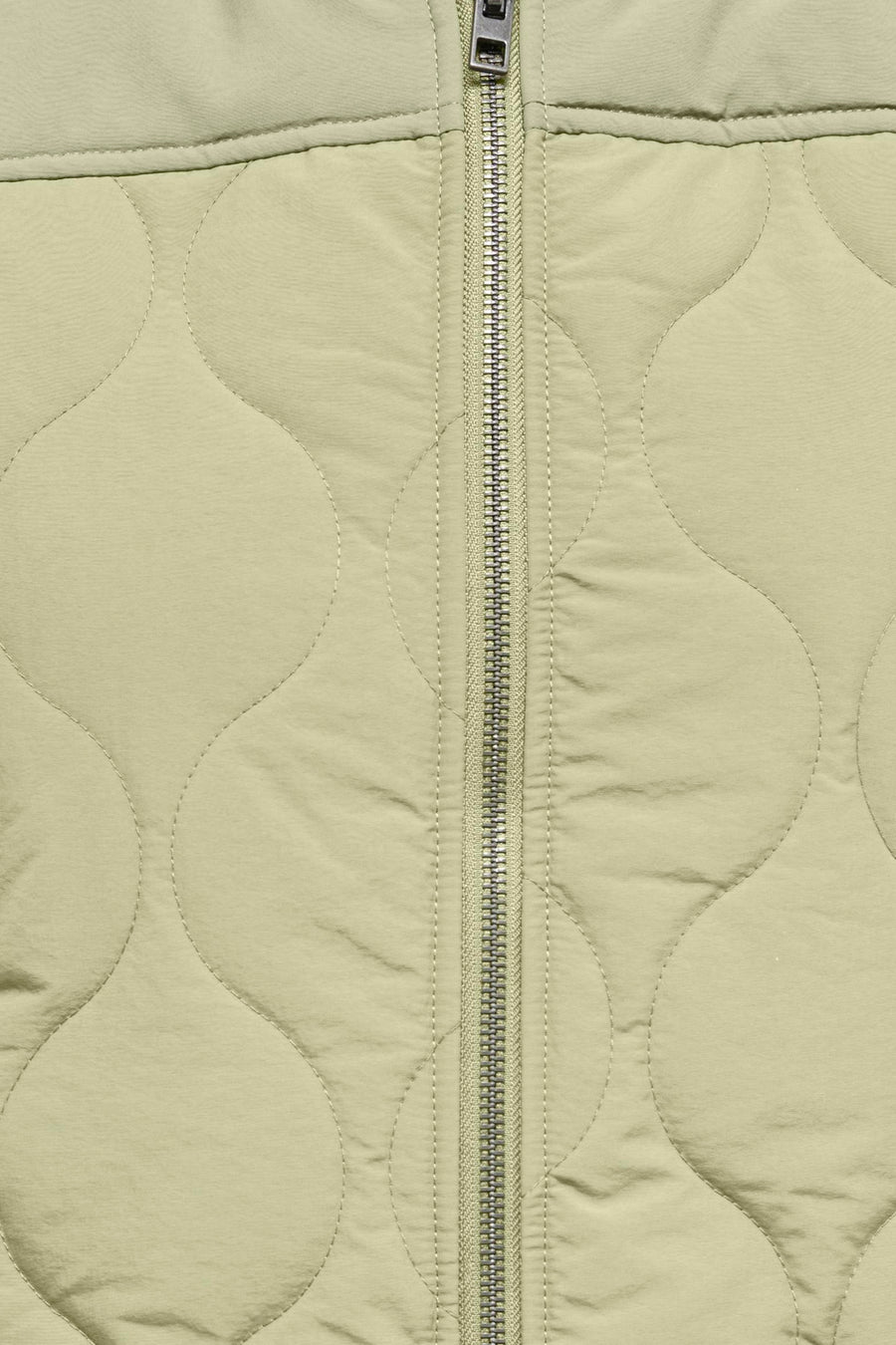 Manteau sans manches vert de JDY avec un motif brodé et doublé et une fermeture éclair argentée.