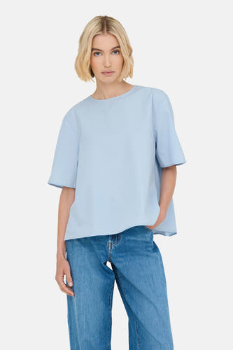 T-shirt bleu à manches courtes de ONLY, porté avec des jeans et une bague en or.