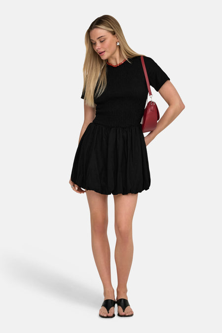Robe noire à manches courtes de ONLY, avec un haut smocké et une jupe ballon.
