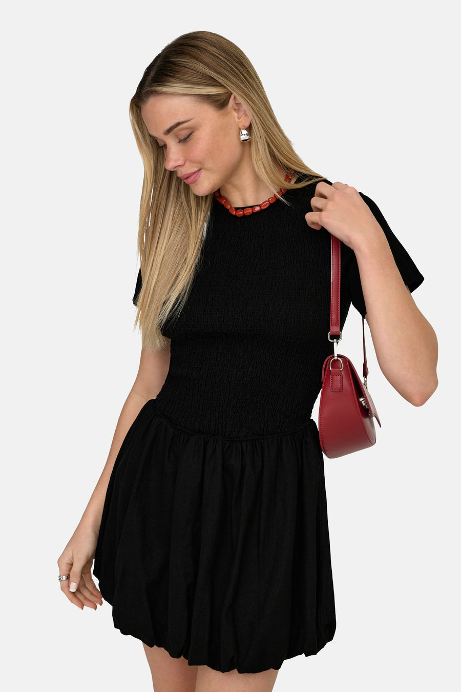 Robe noire à manches courtes de ONLY, avec une taille smockée et un sac à main rouge.