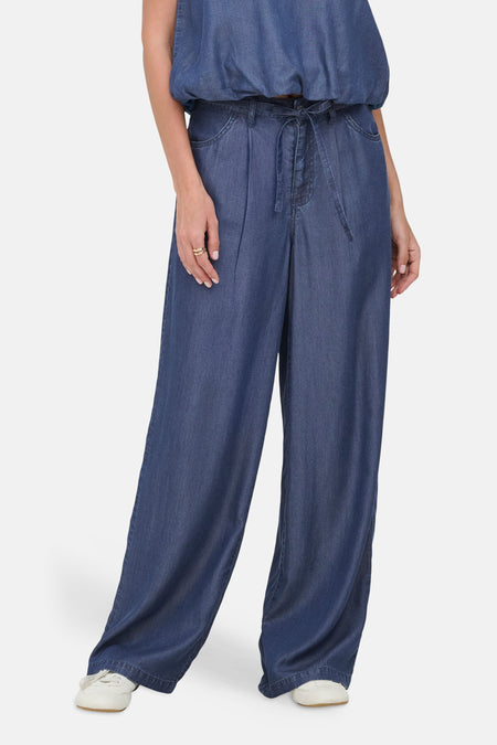Pantalon en denim bleu foncé de ONLY, avec jambes larges et ceinture à nouer, combiné avec un top assorti sans manches.