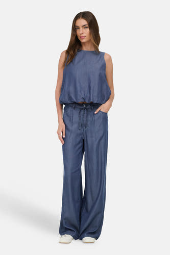 Donkerblauwe denim blouse zonder mouwen van ONLY®, gecombineerd met bijpassende wijde broek, gedragen door een model.