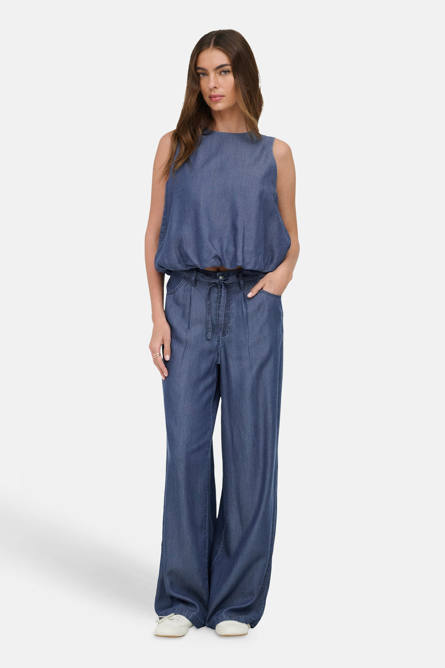 Donkerblauwe denim blouse zonder mouwen van ONLY®, gecombineerd met bijpassende wijde broek, gedragen door een model.