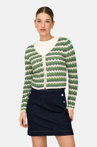 Cardigan vert de ONLY, avec des rayures de couleur crème et porté sur une chemise blanche et une jupe bleu foncé.