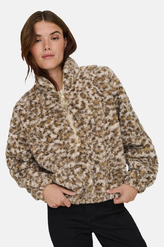 Manteau en polaire beige de ONLY®, avec un motif tacheté marron et blanc, fermeture à glissière courte et pantalon noir.