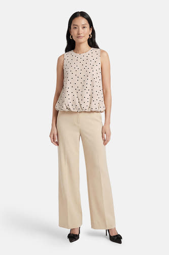 Ecru mouwloze top van ONLY® met zwarte stippen en een geblouzeerde zoom, gedragen met een beige broek.