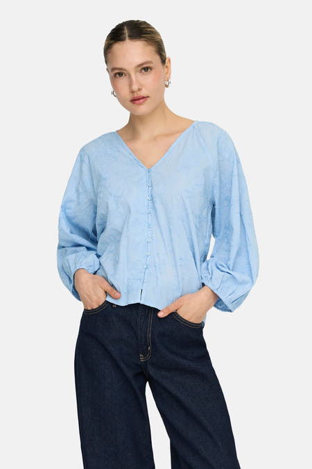 Chemisier bleu à manches longues de ONLY, avec motif fleuri et manches longues bouffantes.