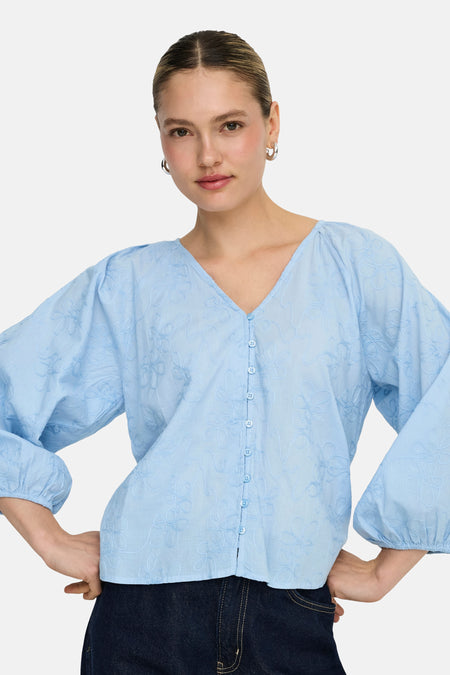 Chemisier bleu à manches longues ONLY®, avec fermeture boutonnée et motifs floraux brodés.
