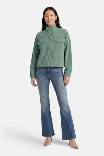 Veste courte verte de ONLY, avec fermeture éclair, poches et portée avec un jean bleu et des escarpins.