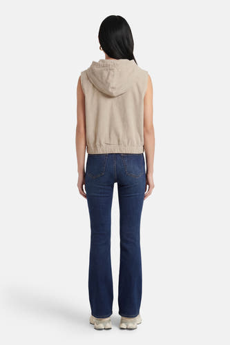 Veste sans manches de couleur écru, par ONLY®, avec une capuche et associée à un jean bleu.