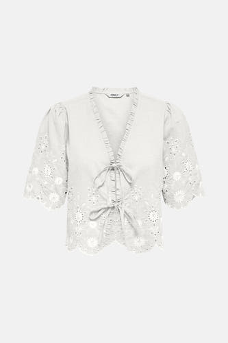 Blouse blanche à manches courtes de ONLY, finie avec des détails de broderie et un bord en dentelle.