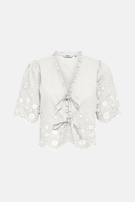 Blouse blanche à manches courtes de ONLY, finie avec des détails de broderie et un bord en dentelle.