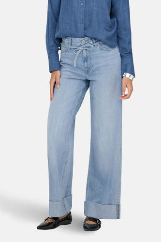 Jean en denim bleu clair large de ONLY, avec une ceinture élastique et des jambes de pantalon relevées, associé à un chemisier bleu et des chaussures noires.