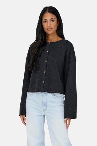 Cardigan gris d'ONLY, porté avec des jeans bleu clair à larges poches et des chaussures noires.