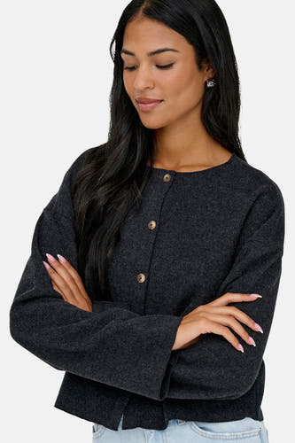 Cardigan gris d'ONLY, avec des manches longues et une fermeture à boutons, porté sur un jean bleu.