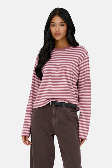 T-shirt rose à manches longues de ONLY®, avec des rayures horizontales et associé à un pantalon marron foncé.